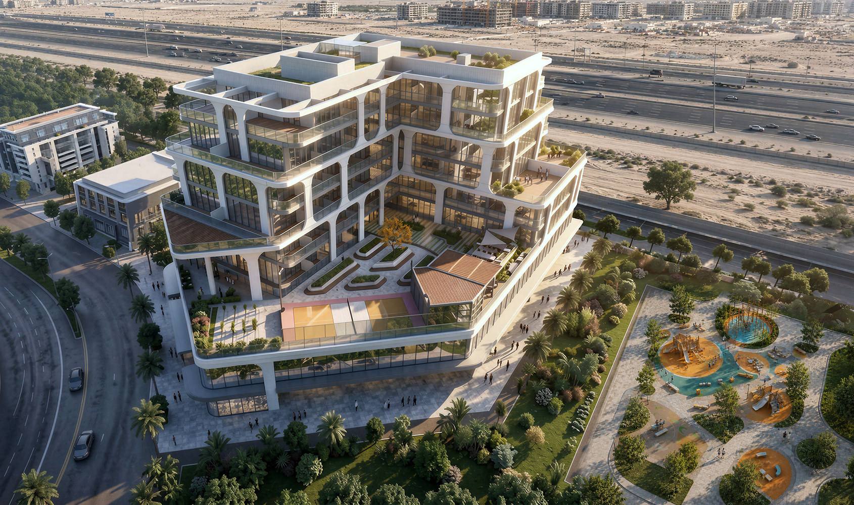 Tomorrow Commercial Tower 2 from above: a stepped low-rise office block beside a landscaped park in International City 2.