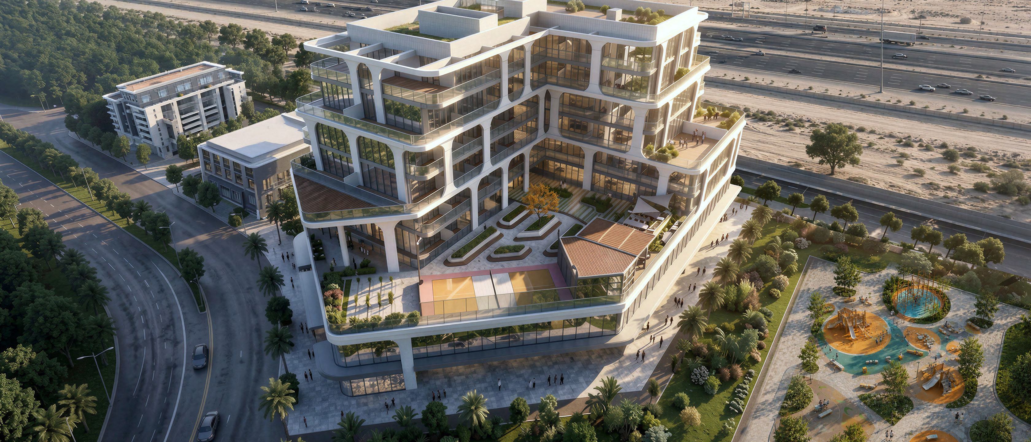 Tomorrow Commercial Tower 2 from above: a stepped low-rise office block beside a landscaped park in International City 2.