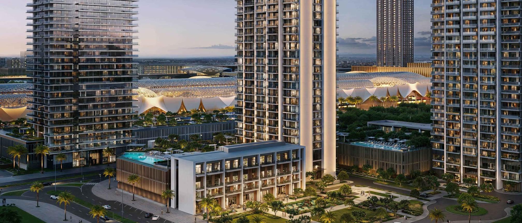 Valia at Dubai Creek Harbour: a slender residential tower with a three-storey clubhouse and pool at its foot, the Dubai Square canopies behind.